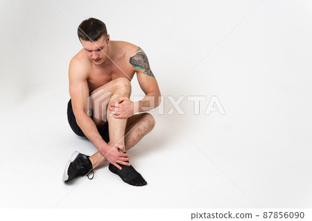 A man's kneecap hurts on a white background back sore man adult, hand chronic. Touching neck therapy, back suffer attractive A man's kneecap hurts on a white background back sore man adult, hand chronic. Touching neck therapy, back suffer attractive 87856090
