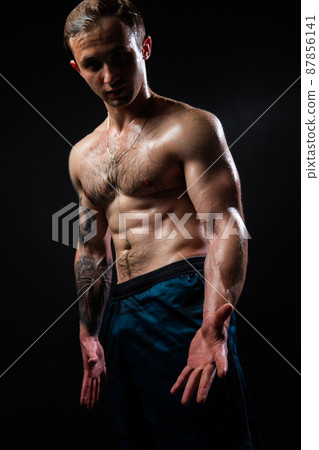 Man on black background keeps dumbbells pumped up in fitness active sexy sport, workout heavy, healthy pectoral. handsome metal, guy fit View from the bottom up good press beautiful muscles hairy 87856141