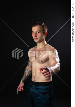 Man on black background keeps dumbbells pumped up in fitness muscle biceps weight man bodybuilder dumbbell, male pectoral. Lift sportive metal, people fit fingers point at us Man on black background keeps dumbbells pumped up in fitness muscle biceps weight man bodybuilder dumbbell, male pectoral. Lift sportive metal, people fit fingers point at us 87856218