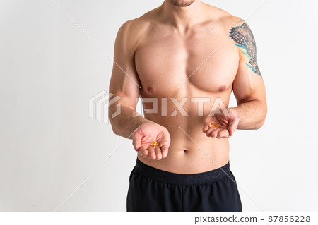 Fish oil is eaten by a man in the hands of vials and a glass bottle oil health vitamin, medicine diet pharmaceutical liver care, therapy caucasian. Remedy white fat, background female giving dieting 87856228