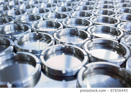 shiny metal rings after turning and milling, silver colored parts on flat steel surface close-up full frame background 87856445