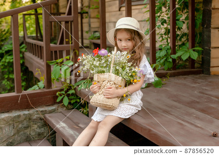 ute little girl sitting on country house threshold with basket of wildflowers ute little girl sitting on country house threshold with basket of wildflowers 87856520