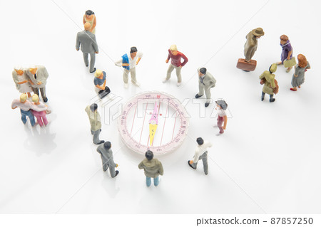 miniature people. different people are standing near the compass. finding direction in life 87857250