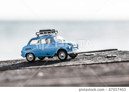 Cute blue retro travel car with luggage. Macro photo Cute blue retro travel car with luggage. Macro photo 87857403