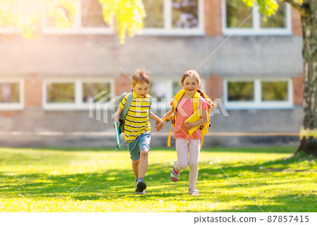 Boy and girl running to the school Boy and girl running to the school 87857415