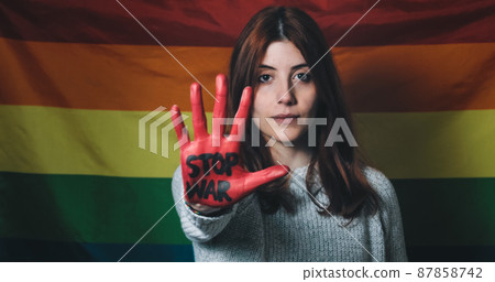 Sad and disappointed girl raises her hand with written no war in front Sad and disappointed girl raises her hand with written no war in front 87858742