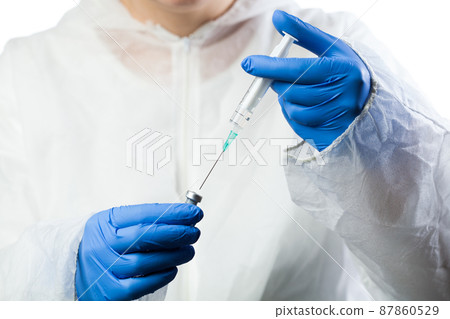 Medical lab technician inserting syringe needle into bottle ampoule 87860529