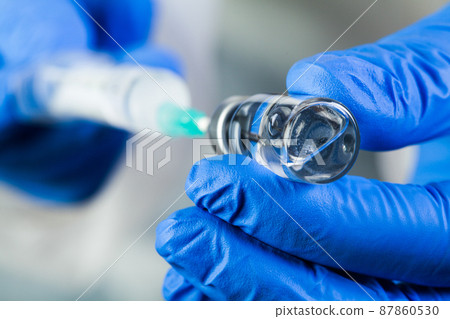 COVID-19 UK vaccine clinical trial concept,hands in blue gloves holding bottle vial COVID-19 UK vaccine clinical trial concept,hands in blue gloves holding bottle vial 87860530