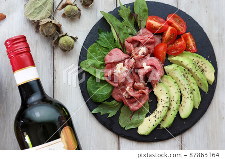 Roast beef and avocado hors d'oeuvre snacks and red wine 87863164