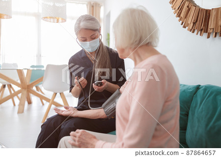 Medical practitioner examining old female at home Medical practitioner examining old female at home 87864657
