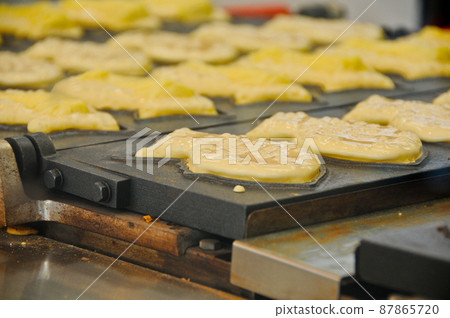 Famous Japanese Taiyaki red bean fish shape dessert snack cooking being made 87865720