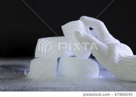 Wear gloves and grab dry ice [black background] 87869295
