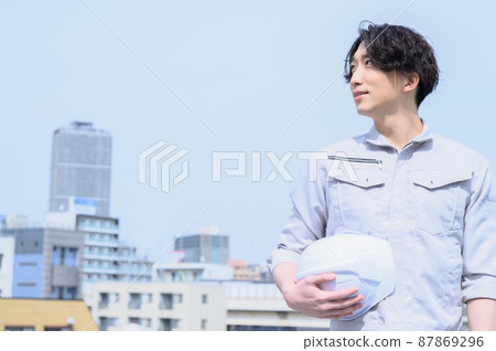 A man looking at the sky in work clothes 87869296