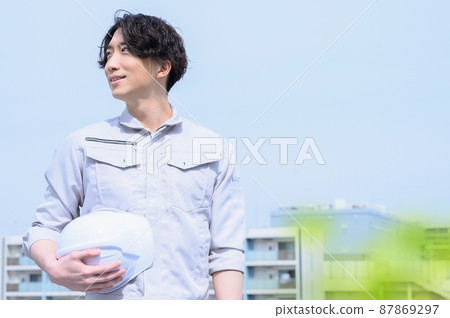 A man looking at the sky in work clothes with blur in front 87869297