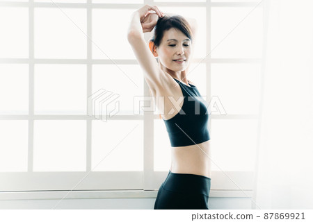 A middle-aged woman with a beautiful body sunbathing in the morning (deep breathing / stretching) 87869921