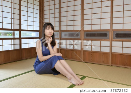 A young woman in a one-piece swimsuit sitting in a Japanese-style room in an old folk house A young woman in a one-piece swimsuit sitting in a Japanese-style room in an old folk house 87872582