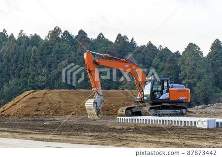 Construction site: Heavy machinery and sand mountains Construction site: Heavy machinery and sand mountains 87873442