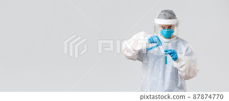 Covid-19, medical research, diagnosis, healthcare workers and quarantine concept. Shocked and excited doctor working on new coronavirus vaccine, pouring liquid in test-tube, stare intense Covid-19, medical research, diagnosis, healthcare workers and quarantine concept. Shocked and excited doctor working on new coronavirus vaccine, pouring liquid in test-tube, stare intense 87874770