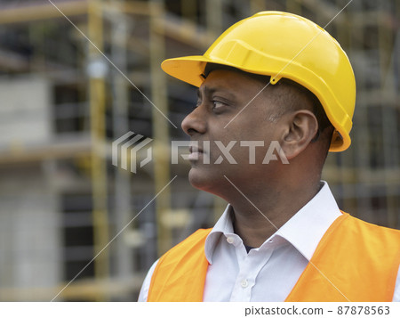 Profile portrait of a serious civil engineer or factory worker wearing a safety helmet and looking aside Profile portrait of a serious civil engineer or factory worker wearing a safety helmet and looking aside 87878563