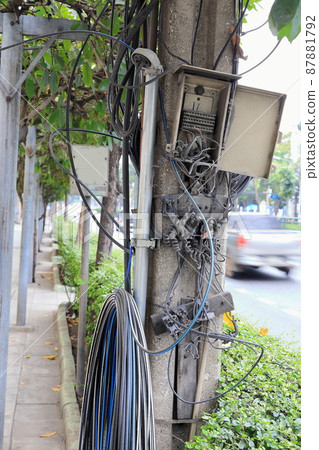 Abandon and broken electrical cable box cabinet on power line pole. 87881792