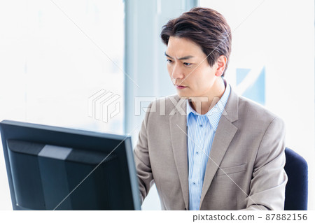 A businessman who uses a personal computer at the office 87882156