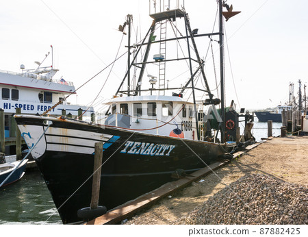 Commercial fishing trawler tied up to a dock 87882425