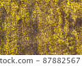 Brown abstract background with acid yellow green red hues. A rust-eaten textured sheet of metal with remnants of paint marks. 87882567