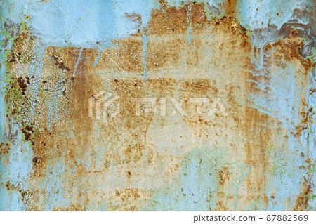 Brown beige abstract background with orange blue hues. A rust-eaten textured sheet of metal with remnants of paint marks. 87882569