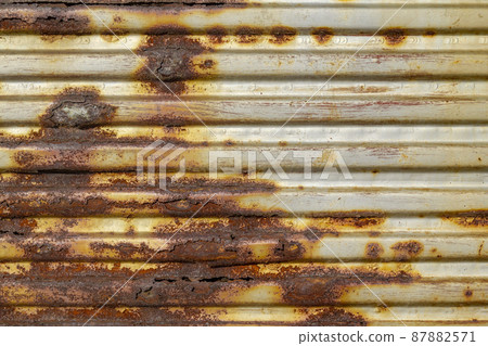 Silver abstract background with pink red brown shades. A rust-eaten ribbed textured sheet of metal with remnants of paint marks. 87882571