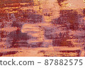 Red brown abstract  background with pink hues. A weathered, rust-eaten textured sheet of metal with traces of paint residue. 87882575