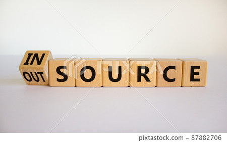 Outsource or insource symbol. Fliped wooden cubes and changed the word 'outsource' to 'insource'. Beautiful white background, copy space. Business and outsource or insource concept. 87882706
