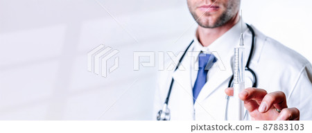 Syringe needle medical injection. Selective focus, doctor hand in blue gloves holding syringe with needle. Hospital white doctor gown, stethoscope. Syringe with flu vaccine with copy space. Syringe needle medical injection. Selective focus, doctor hand in blue gloves holding syringe with needle. Hospital white doctor gown, stethoscope. Syringe with flu vaccine with copy space. 87883103