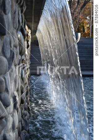 A waterfall of a fountain in a garden 87884016