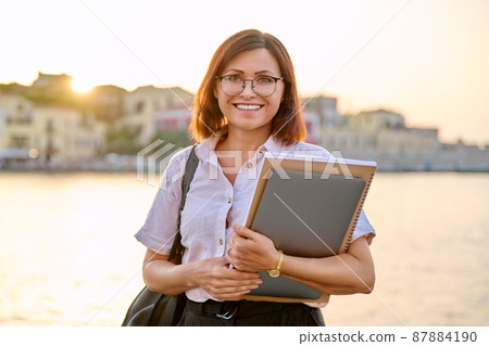 Portrait middle aged businesswoman with laptop in hand, looking in camera 87884190