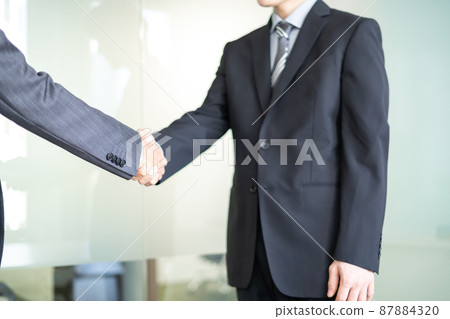 一個西裝革履的商人,面無表情地握手 一個西裝革履的商人,面無表情地握手 87884320