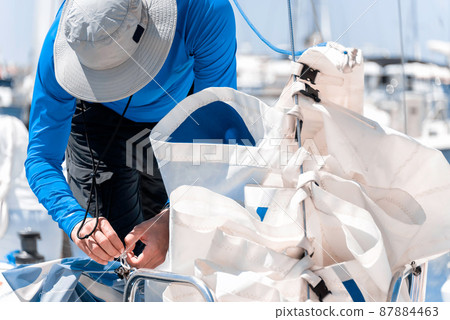 Man preparing sails for regatta Man preparing sails for regatta 87884463