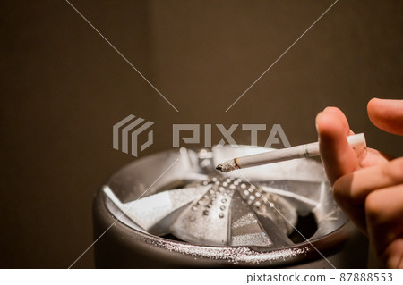 Hands of a person who smokes in a smoking area 87888553