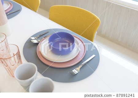 Beautiful table setting with pink and purple plate on table. Glassware and cutlery for catered event dinner. Beautiful table setting with pink and purple plate on table. Glassware and cutlery for catered event dinner. 87891241