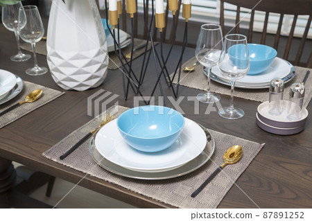 Modern dinning room interior with blue plate on wood table at home. Modern dinning room interior with blue plate on wood table at home. 87891252
