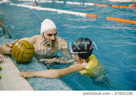 Girl learning to swim with coach at the leisure center Girl learning to swim with coach at the leisure center 87892286