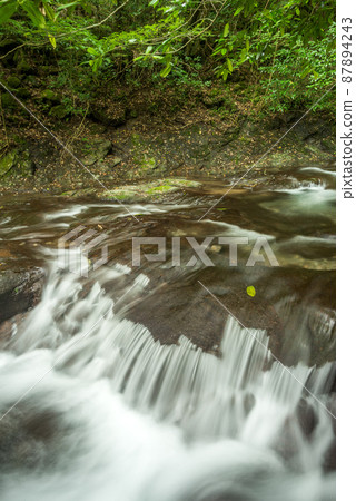 A shallow river flowing down a rocky step A shallow river flowing down a rocky step 87894243