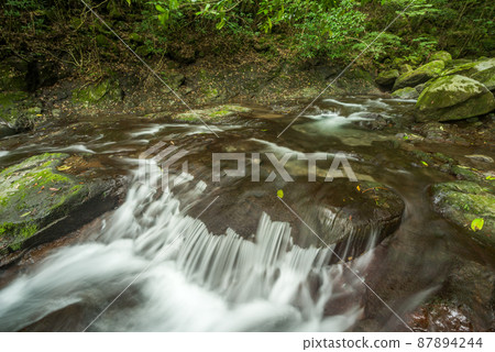 A shallow river flowing down a rocky step A shallow river flowing down a rocky step 87894244