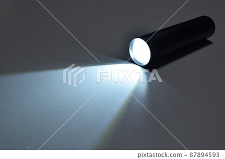 Black flashlight that is lit Black flashlight that is lit 87894593