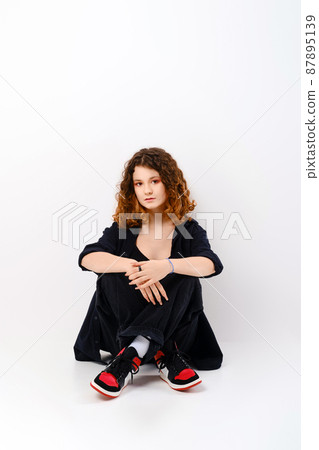 Cute girl sitting in studio on the floor 87895139