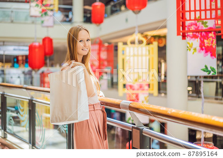 Woman hold shopping bag against the background of Chinese red lanterns for the Chinese New Year. Big sale in honor of the New Year's Eve. Black Chinese Friday 11.11 87895164