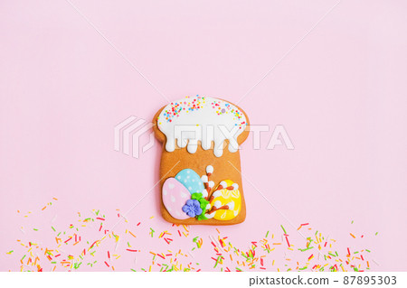 Gingerbread in the form of a easter cake and and sweet color sprinkles on pink background. Gingerbread in the form of a easter cake and and sweet color sprinkles on pink background. 87895303