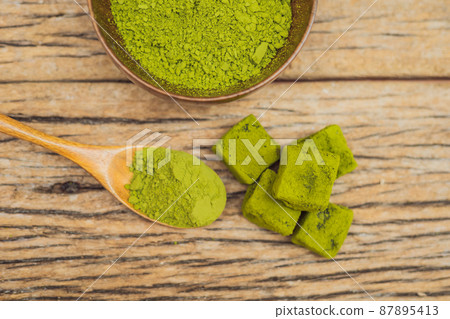 Matcha powder and candy made of matcha on wooden background. Homemade Matcha Matcha powder and candy made of matcha on wooden background. Homemade Matcha 87895413