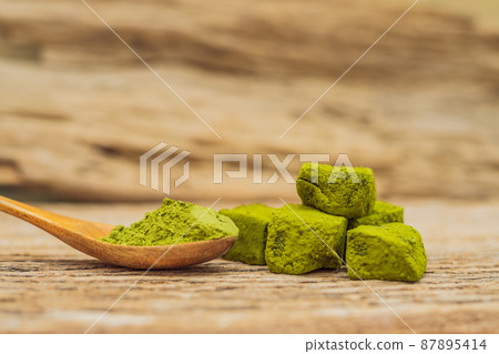 Matcha powder and candy made of matcha on wooden background. Homemade Matcha 87895414