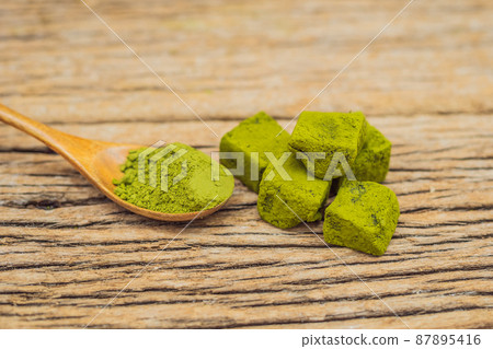 Matcha powder and candy made of matcha on wooden background. Homemade Matcha 87895416