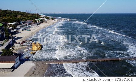 People walking and relaxing on beach on sunny day. Aerial Drone View Flight Over People walking and relaxing on beach on sunny day. Aerial Drone View Flight Over 87897108